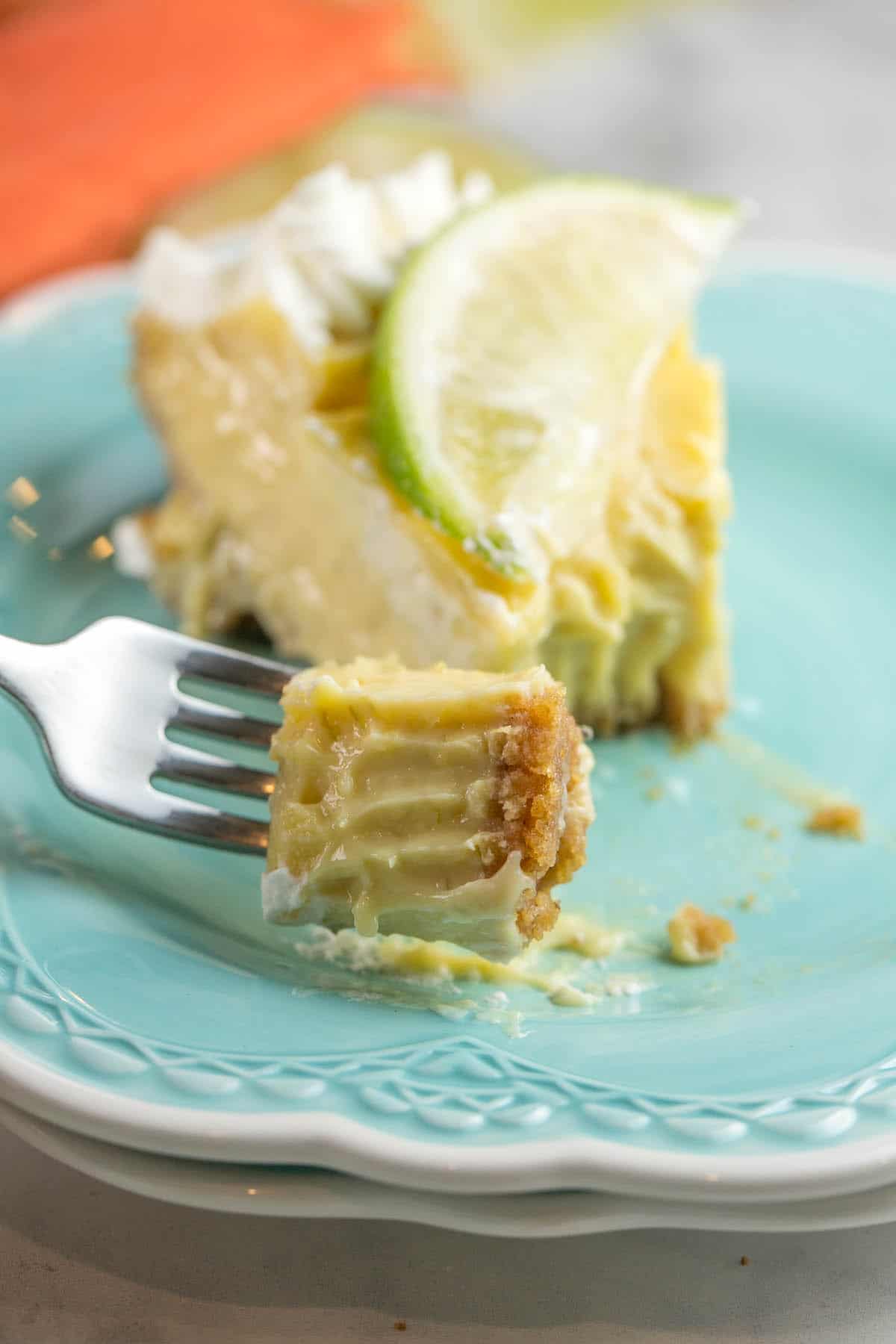 a fork holding a bite size amount of a silky smooth lime custard pie