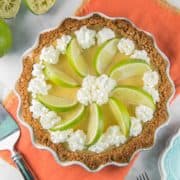 lime custard pie made with tequila in a graham cracker crust decorated with whipped cream and lime slices