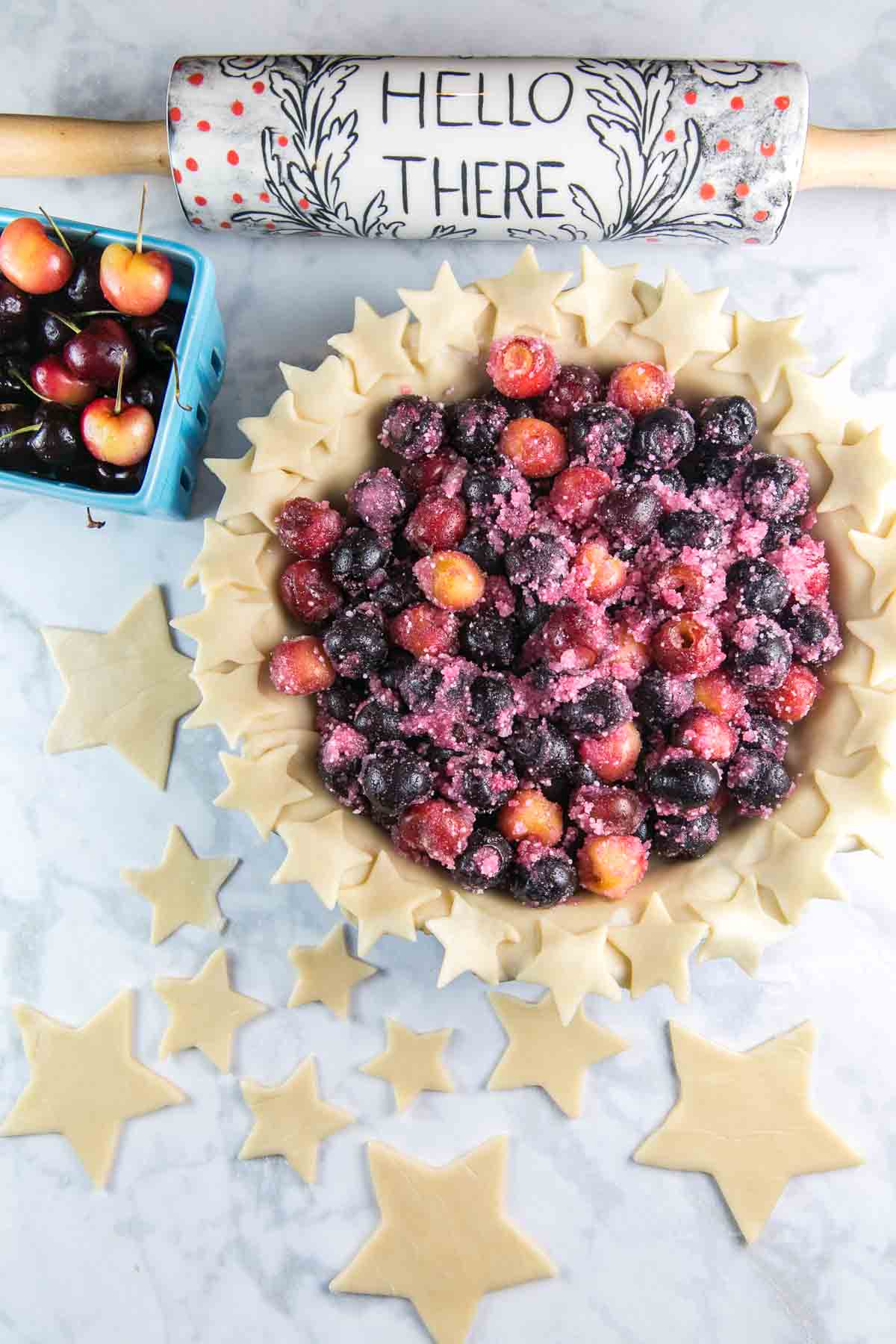 unbaked pie crust filled with whole fresh cherries ready to bake