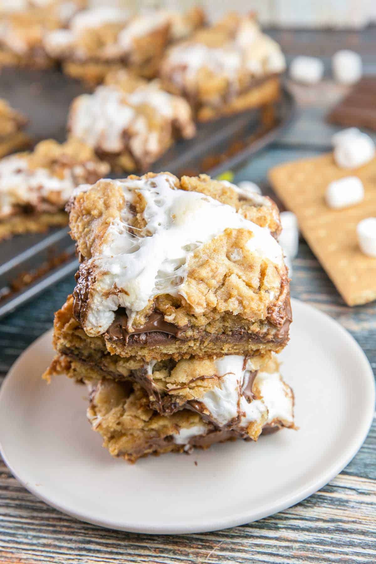 a stack of baked s'mores bars with gooey marshmallow on top