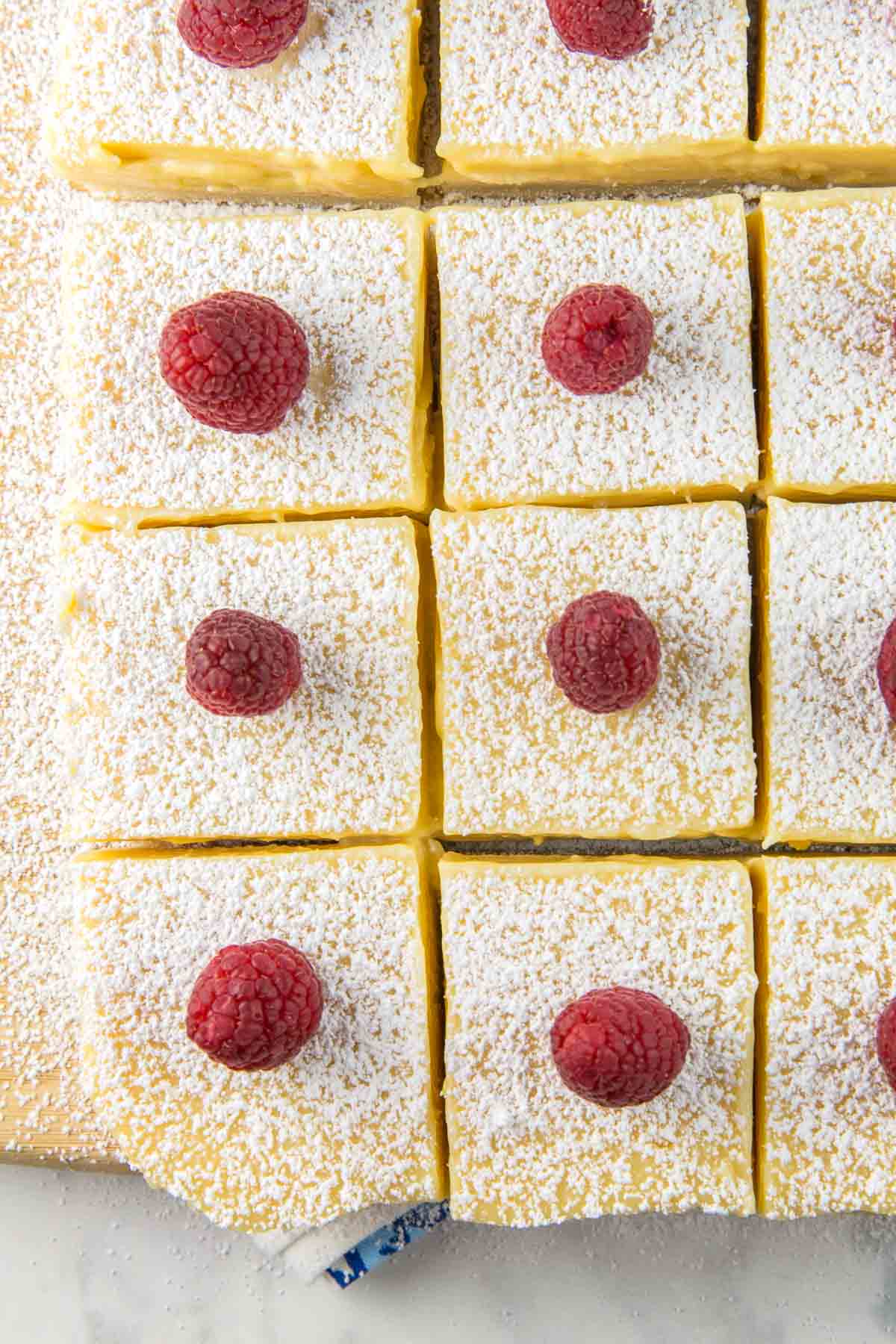 squares of lemon bars made with lemon pie filling and topped with raspberries