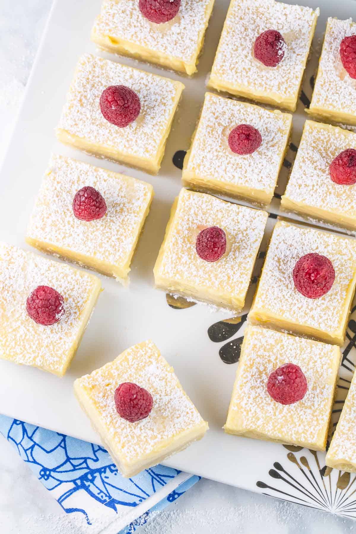 rows of lemon bars on a white serving plate