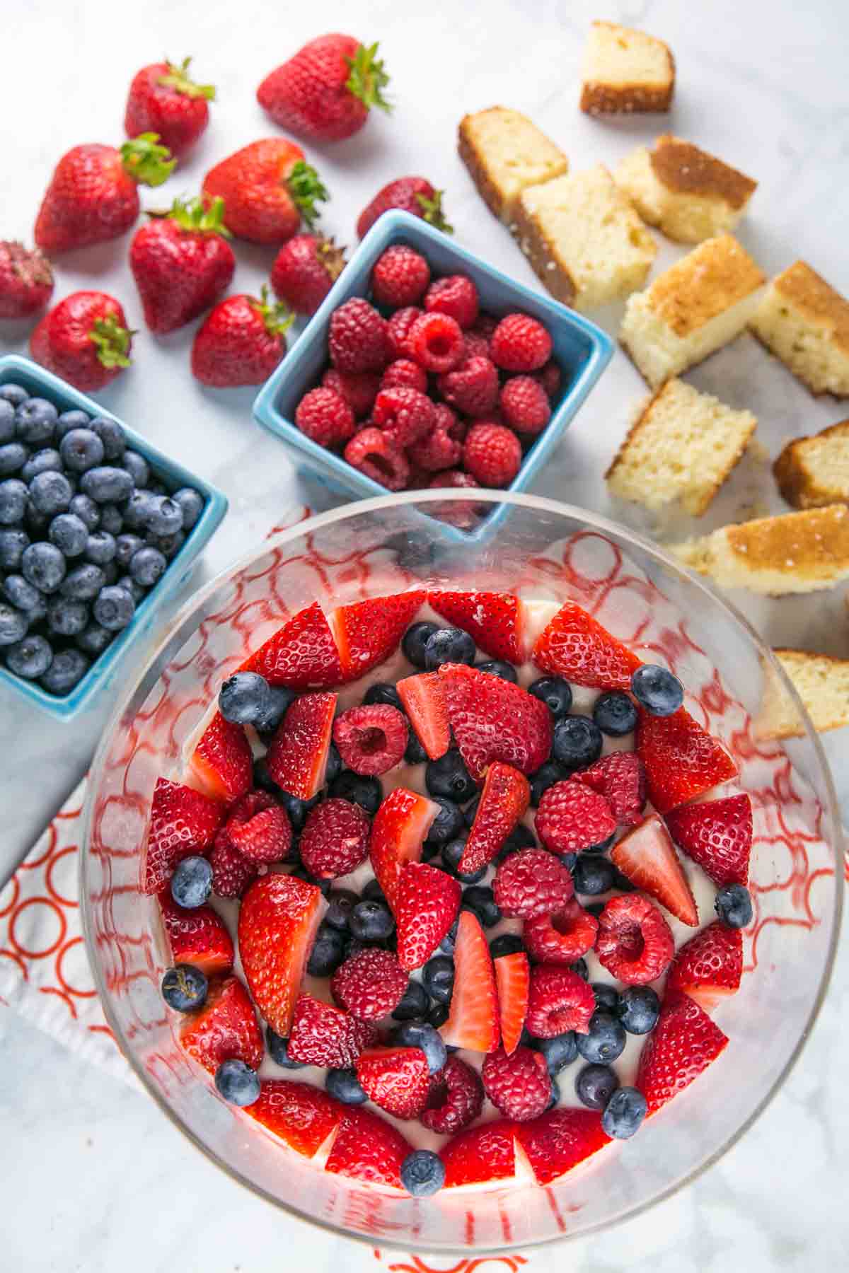 layers of fresh summer berries arranged in a trifle bowl