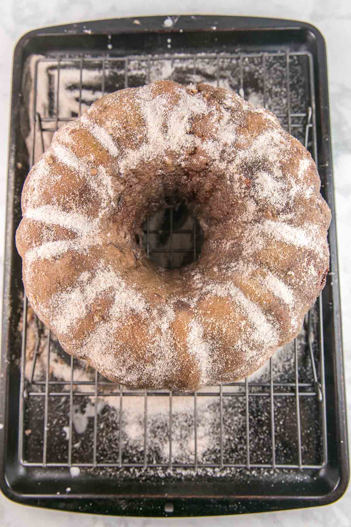 bundt cake on a wire rack covered in cinnamon and sugar