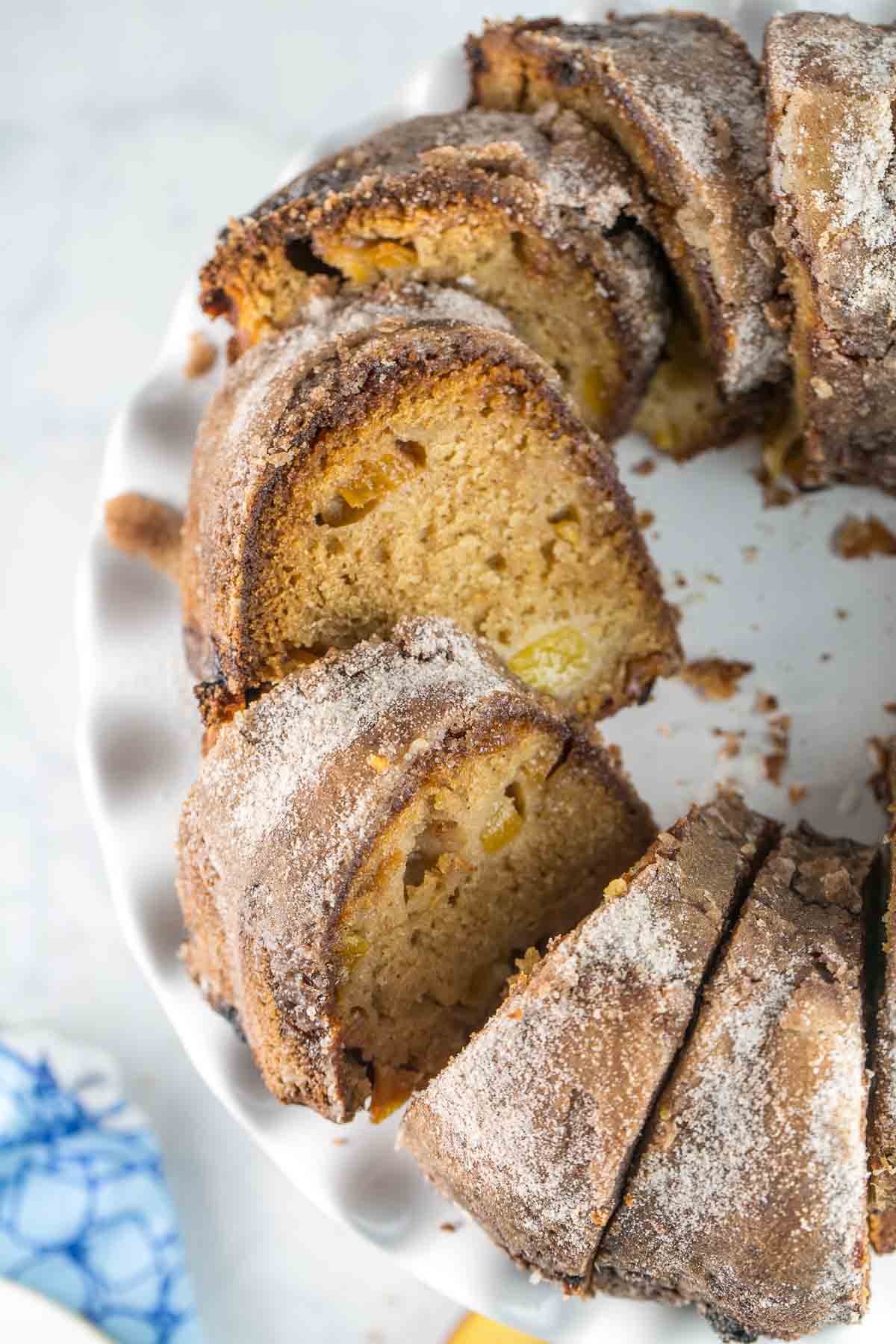 sliced peach bundt cake on a white cake stand