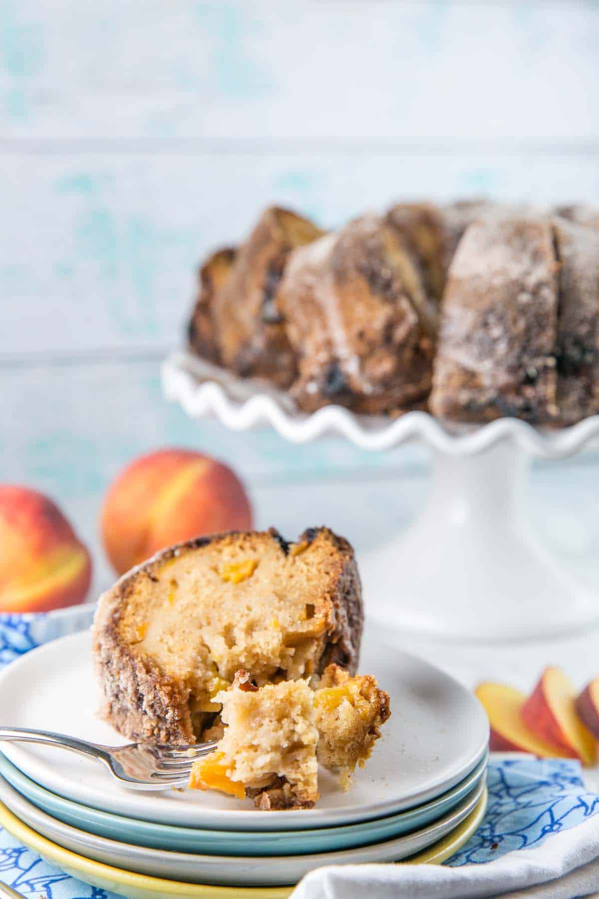 a forkful of bundt cake showing chunks of fresh peaches in the cake