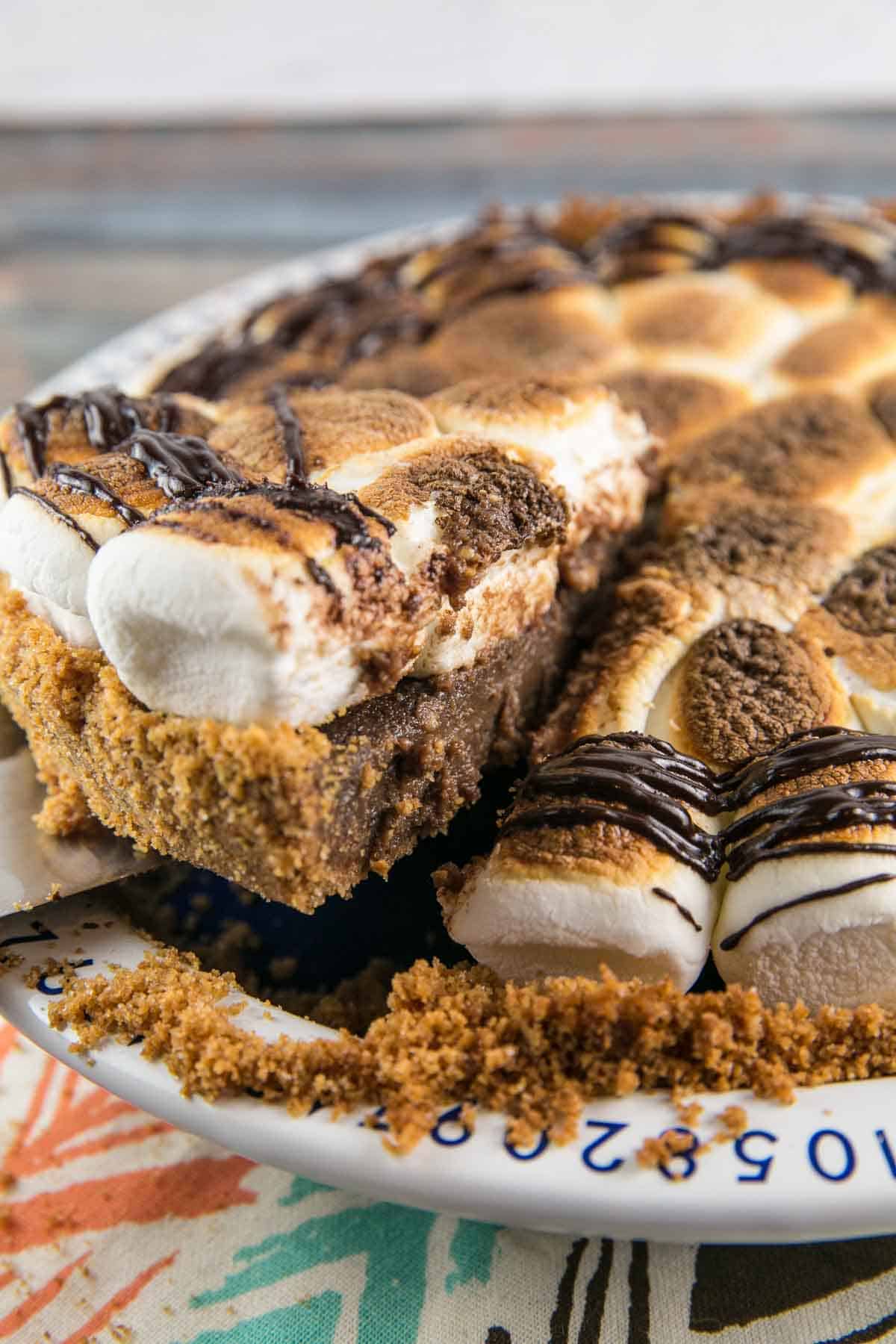 a slice of gooey smores pie being lifted out of the pie dish