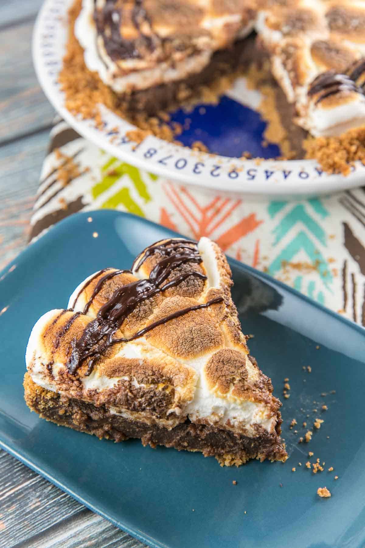 a slice of chocolate pie with jumbo toasted marshmallows on a blue rectangular plate