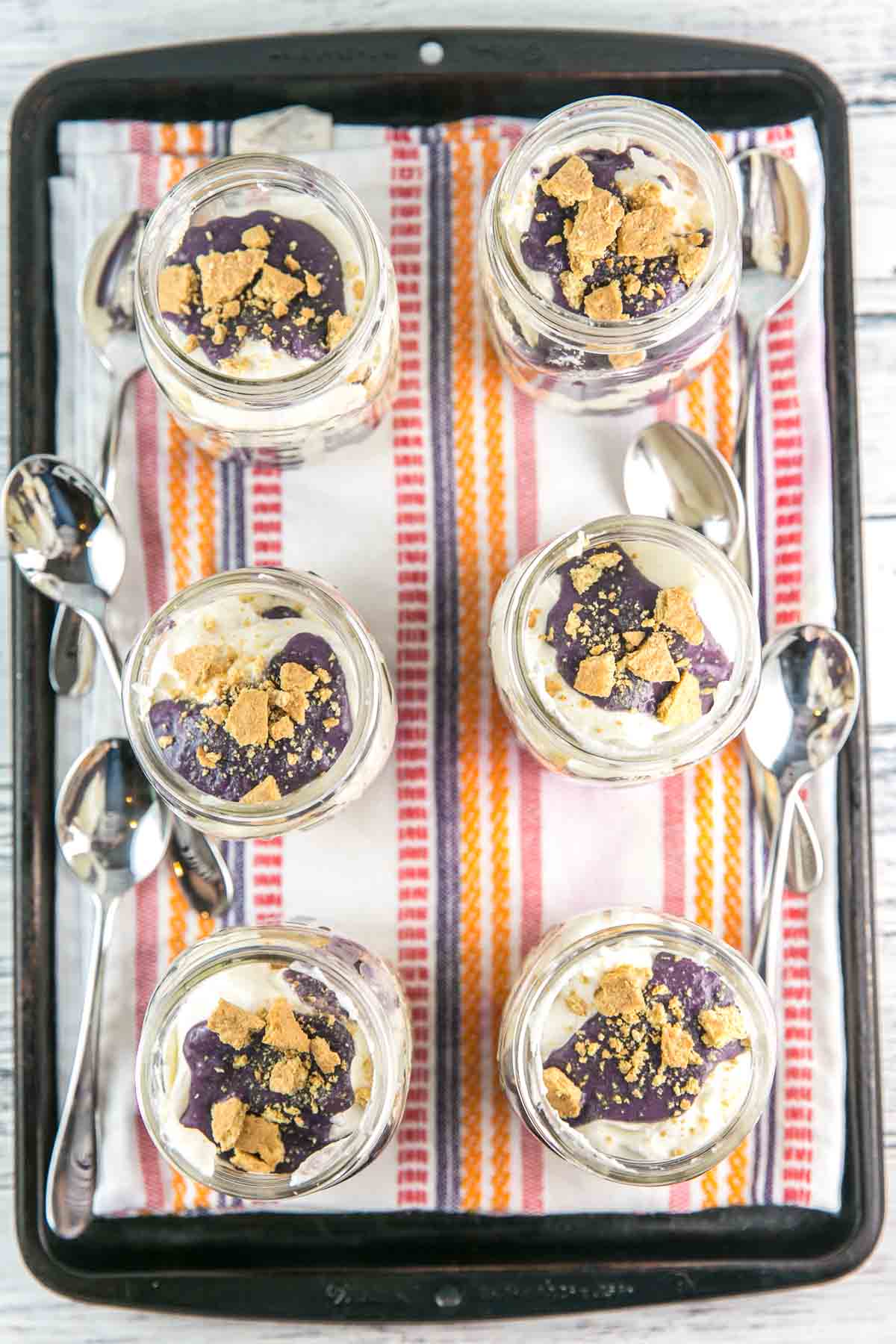 overhead view of mason jars filled wit no bake cheesecakes on a serving tray