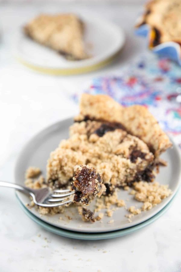 a slice of wet bottom chocolate shoofly pie with a fork holding up a bite exposing the chocolate and molasses bottom layer