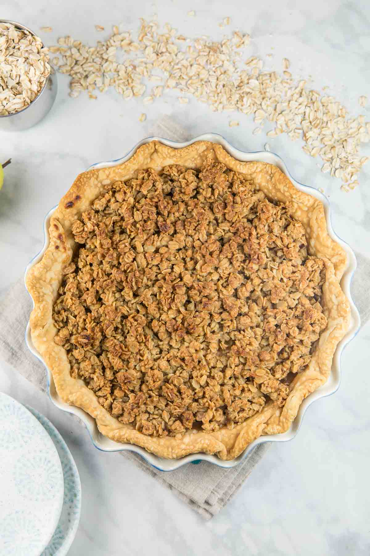 overhead view of a baked caramel pear pie covered in a golden oatmeal cookie crumble.