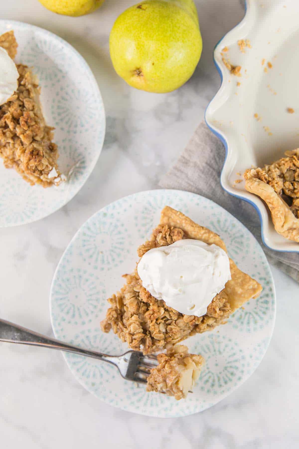 slices of caramel pear pie with a dollop of whipped cream.