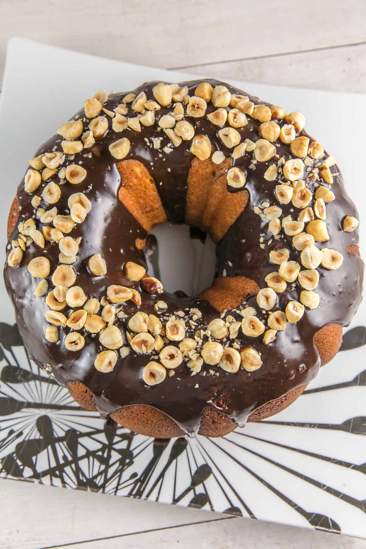 whole nutella bundt cake with nutella glaze topped with chopped hazelnuts