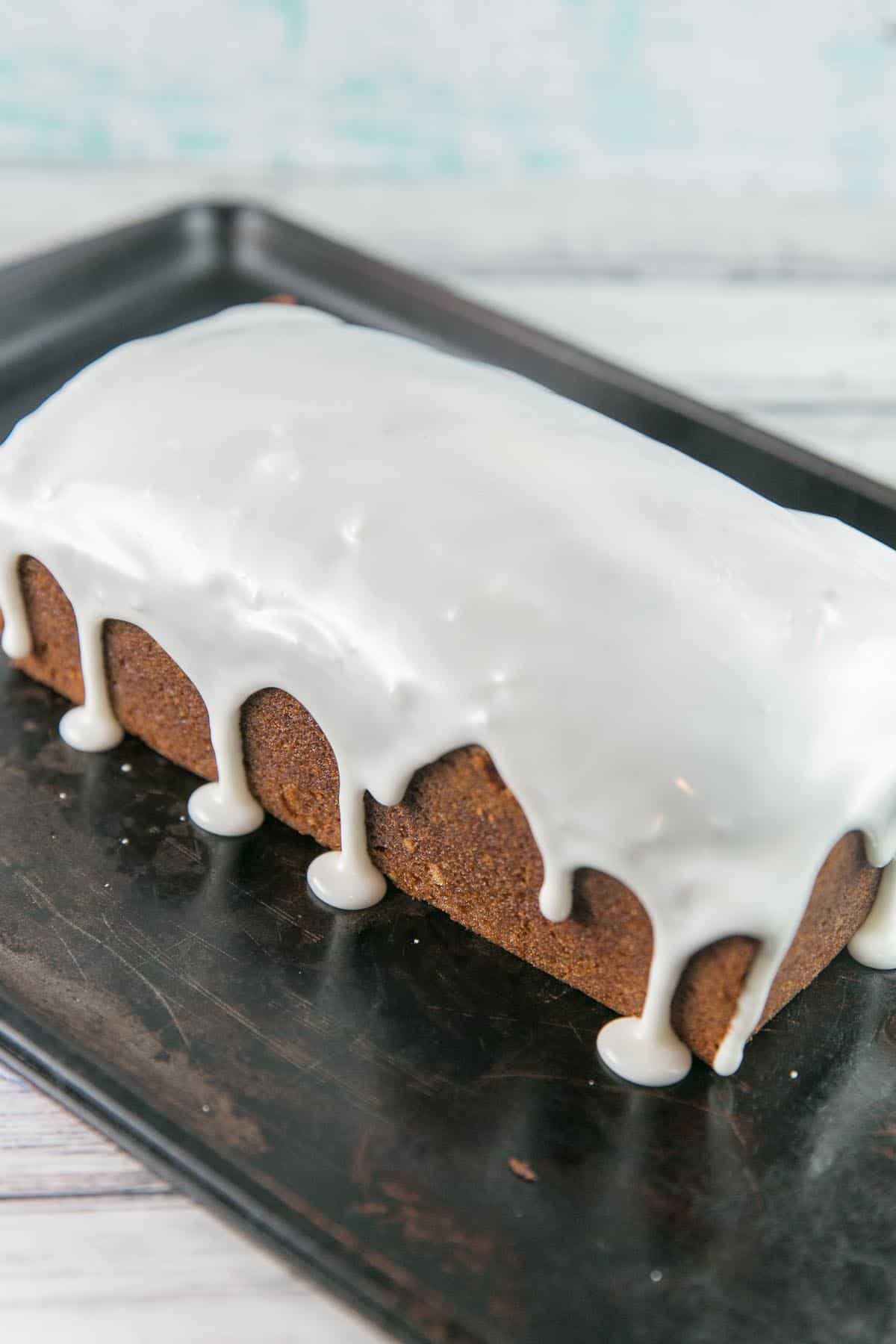 lemon pound cake covered in lemon glaze dripping over the sides of the loaf