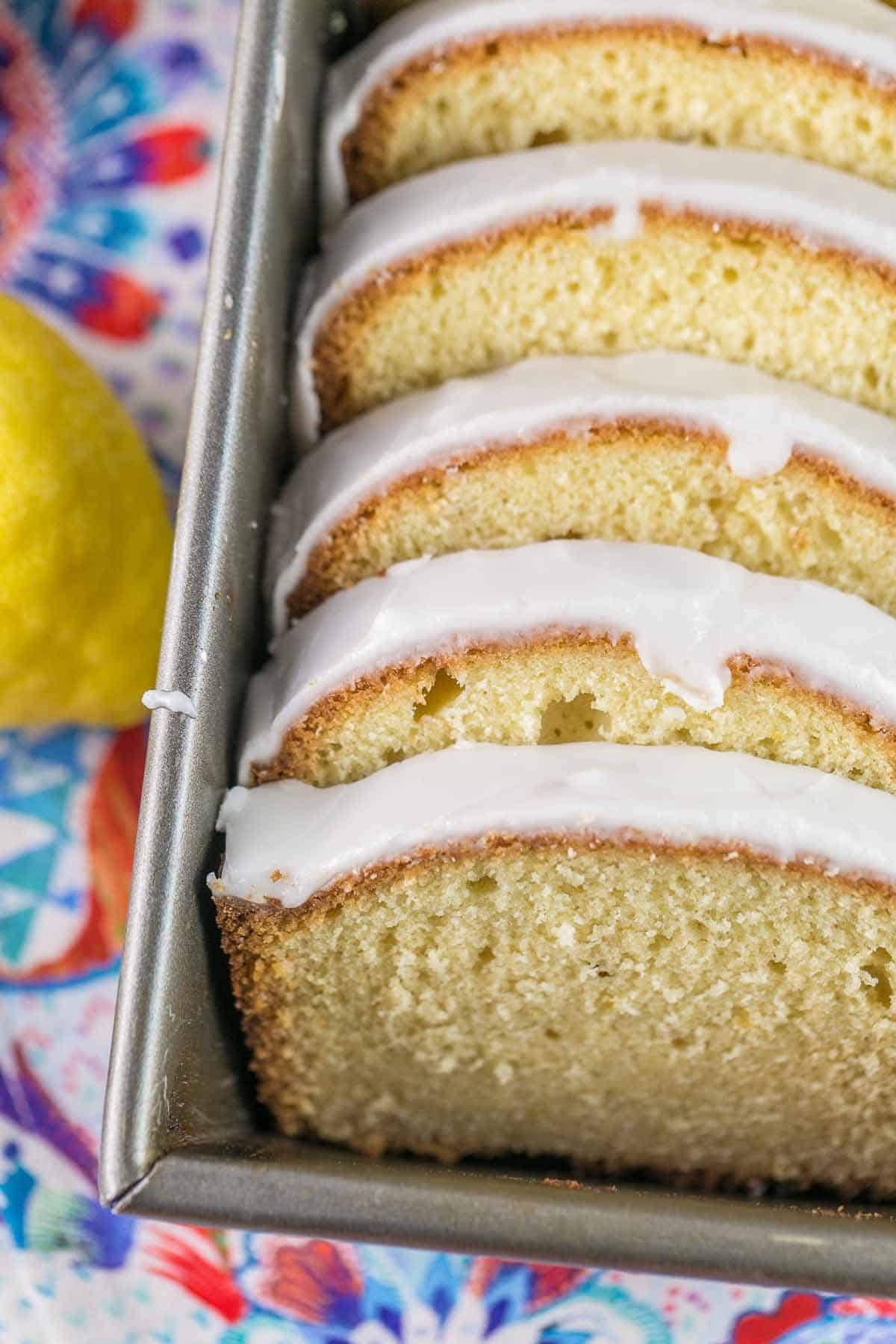 closeup view of slices of glazed lemon pound cake arrange in a loaf pan