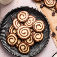 pinwheel cookies on a round textured black plate