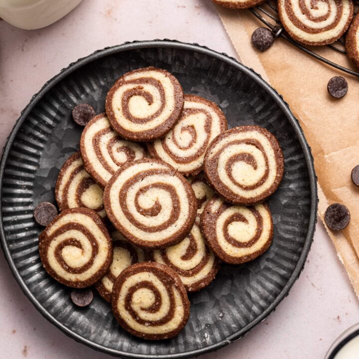 pinwheel cookies on a round textured black plate