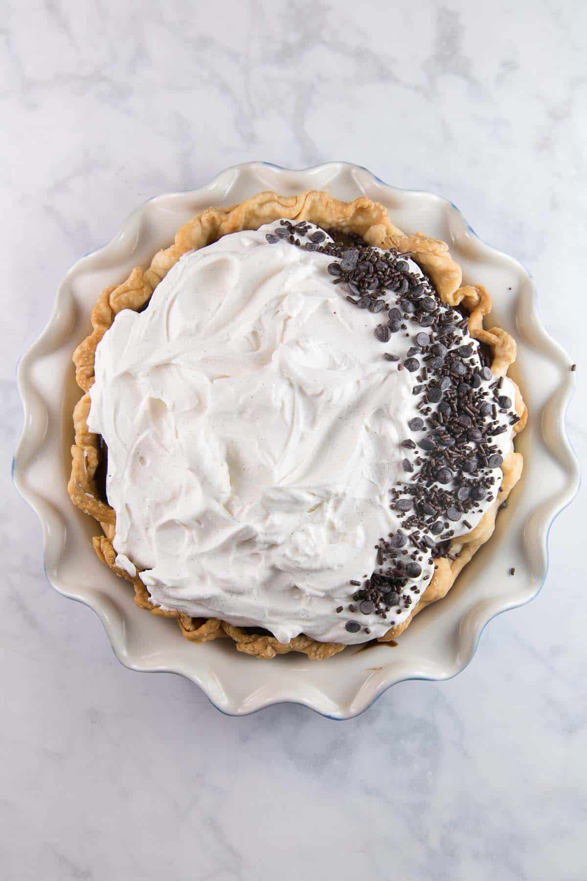 overhead photo of a whole chocolate cream pie with chocolate sprinkles