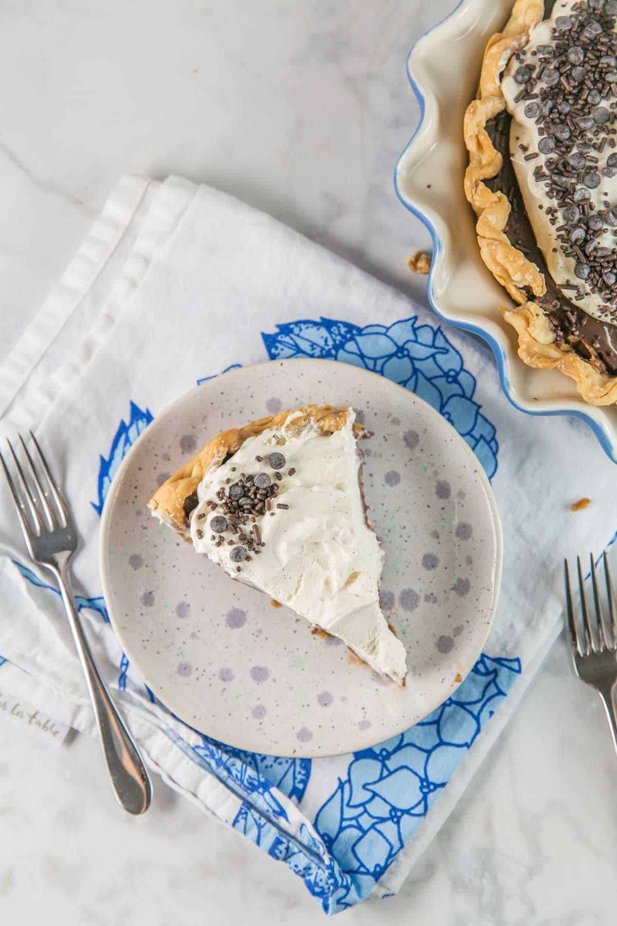 overhead picture of a slice of chocolate cream pie on a purple dessert plate
