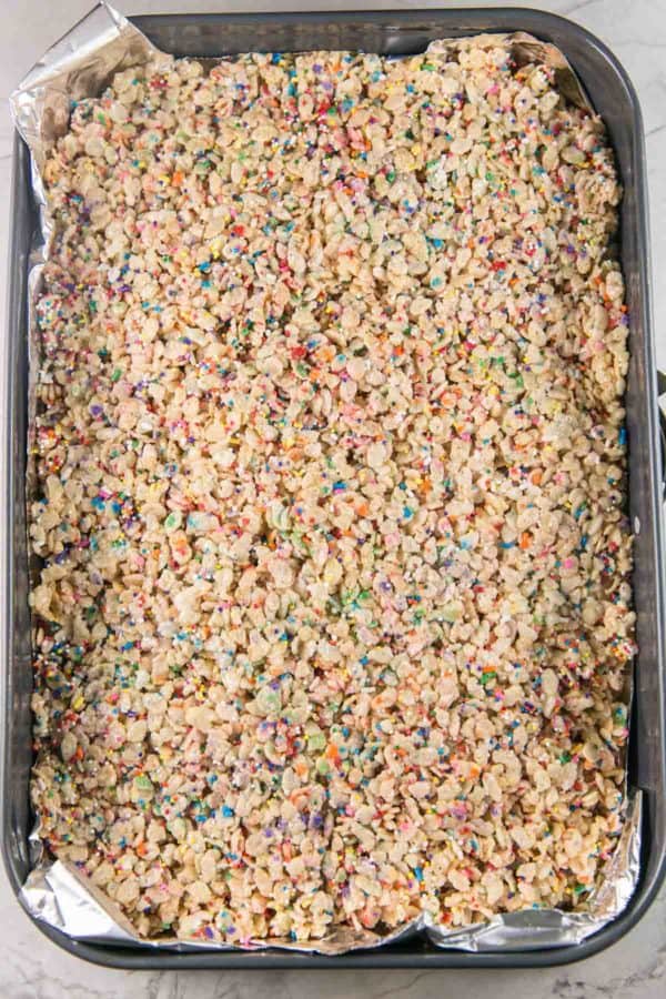 a large pan of uncut rice krispie treats mixed with rainbow sprinkles.