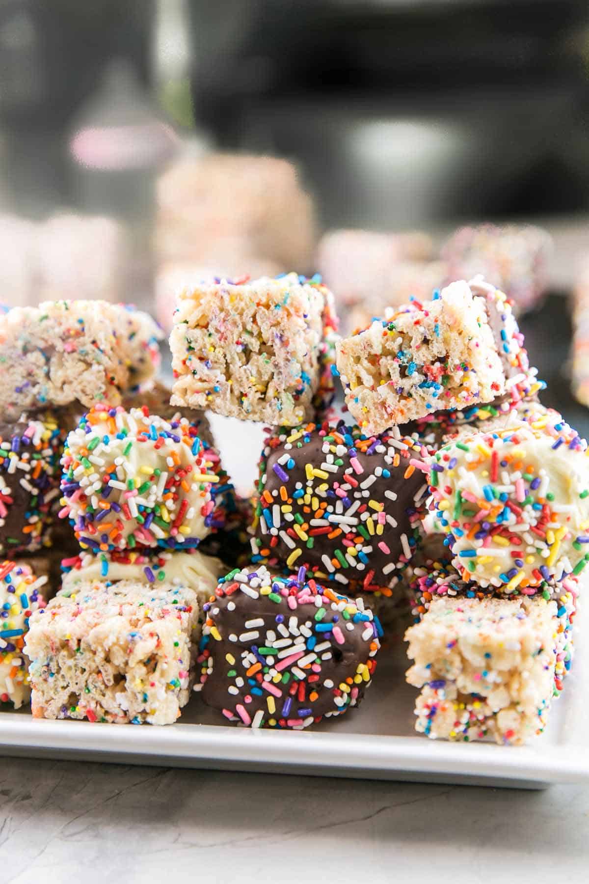 side view of a stack of chocolate dipped sprinkle rice krispie treats