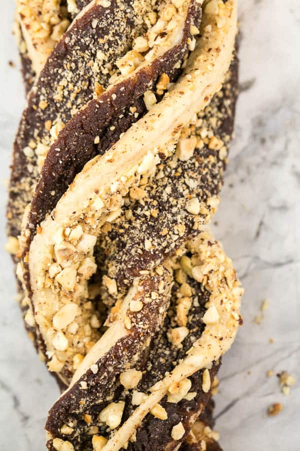 close up view of an unbaked cinnamon hazelnut babka highlighting the swirled dough and chopped hazelnuts