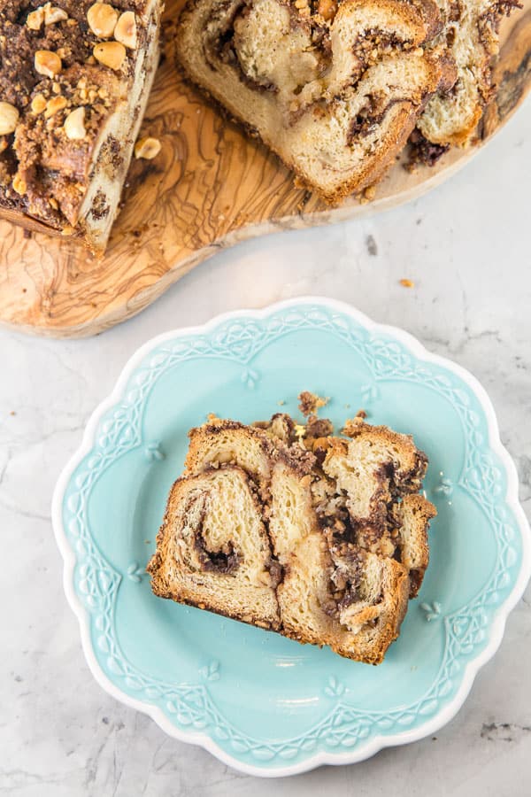 one slice of cinnamon hazelnut babka on a decorative blue plate.