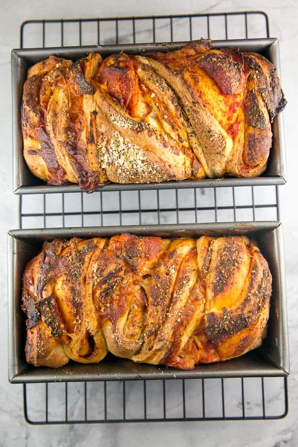 two loves of baked pizza babka cooling in loaf pans.