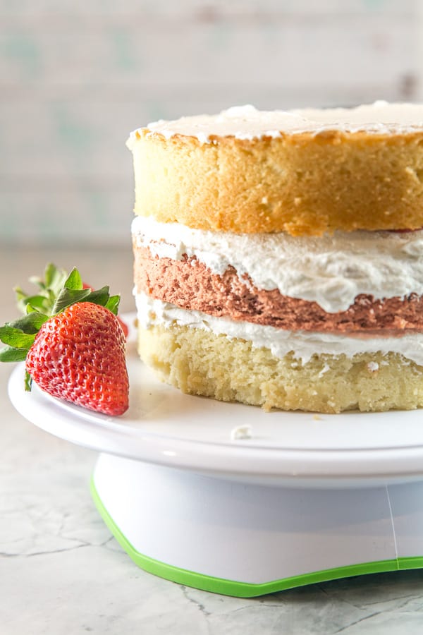 a three layer strawberry layer cake stacked but not yet frosted