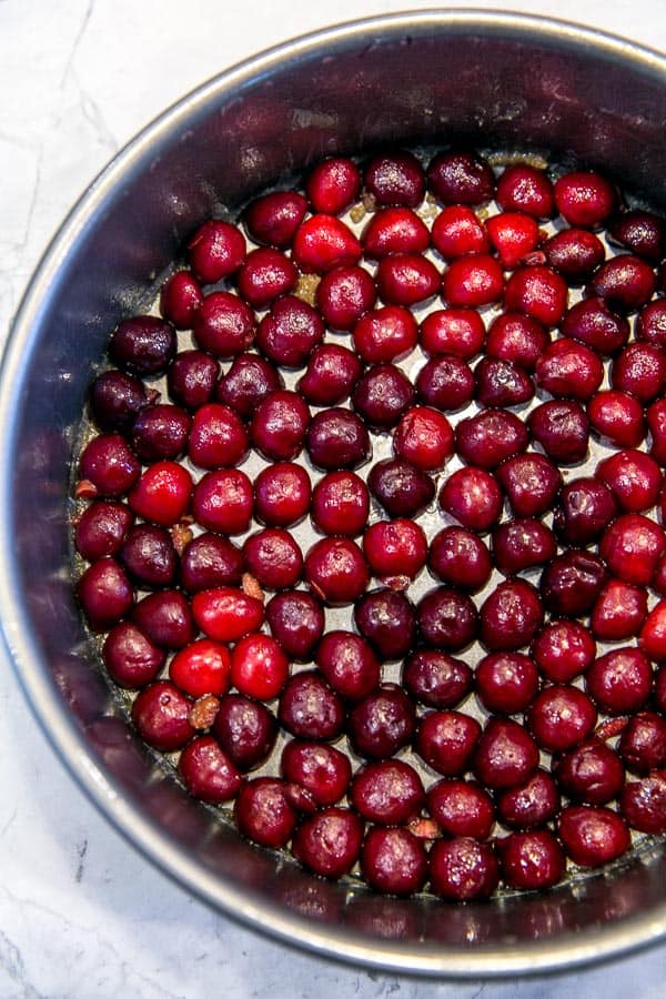 halved cherries lining the bottom of a springform pan to make a cherry upside down cake