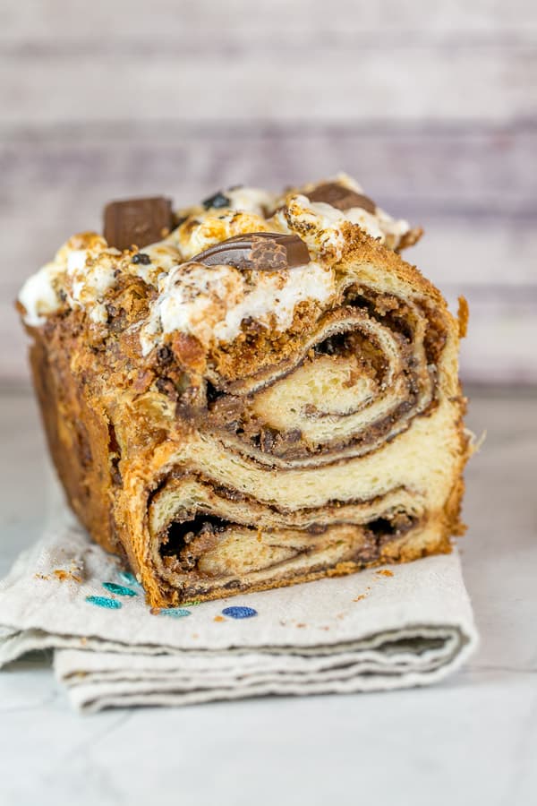 half a loaf of s'mores babka bread sliced to show the swirls of chocolate and marshmallow inside