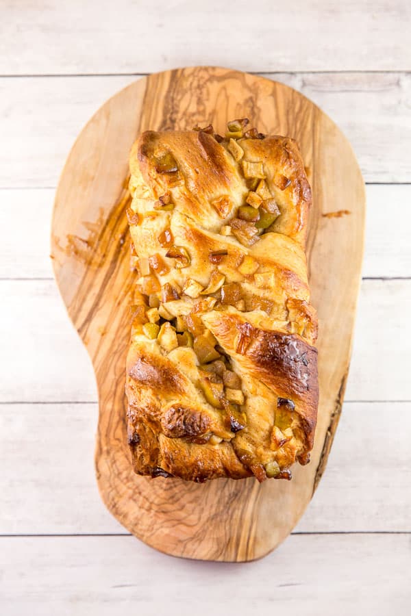 a large loaf of honey apple babka on a wooden board