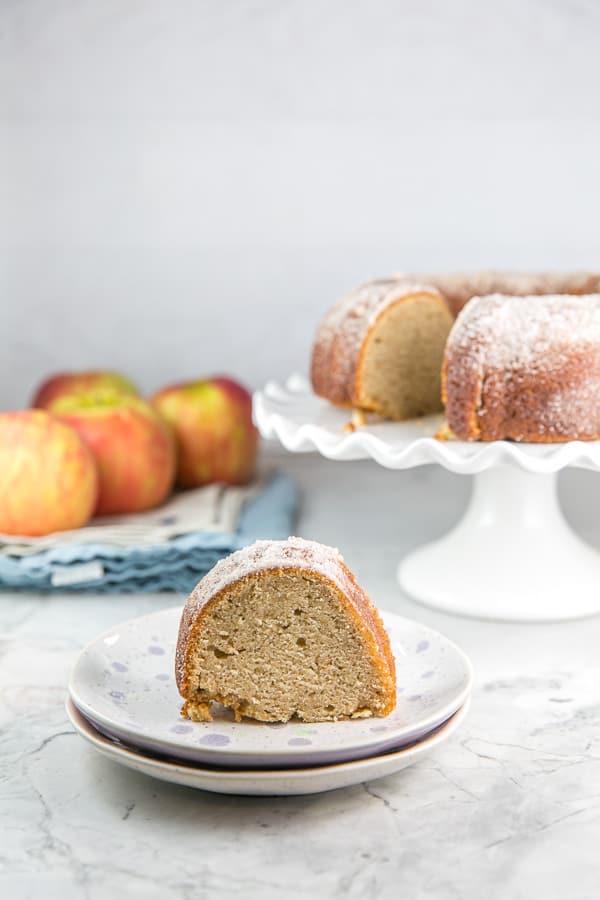 one slice of an apple cider donut bundt cake on a dessert plate.