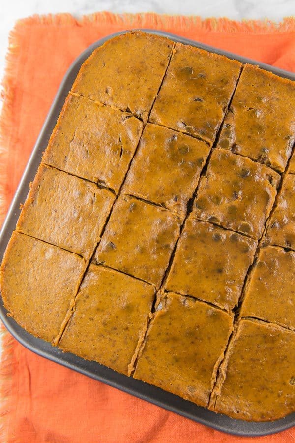 a dish of pumpkin pie bars still in the tray sliced but not yet removed from the baking dish