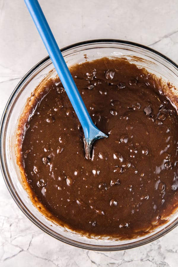 a glass mixing bowl filled with homemade brownie batter for perfect chewy brownies
