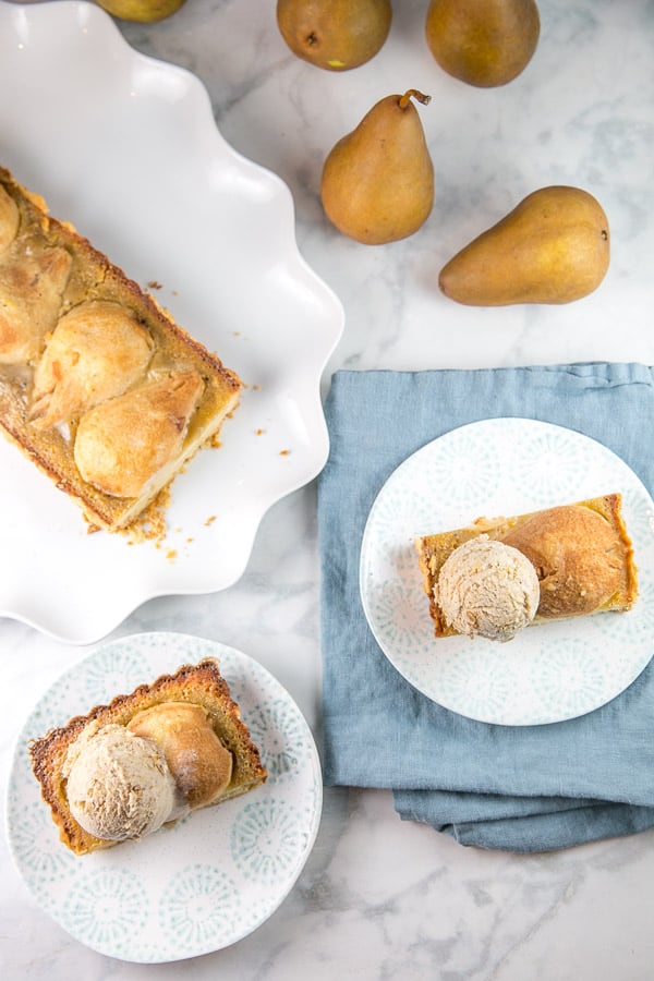 scoops of oatmeal cookie ice cream pictured on top of a slices of a browned butter pear tart