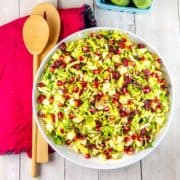 Shaved Brussels Sprout Salad: Full of shredded brussels sprouts, apples, pomegranate arils, and sunflower seeds, this make-ahead salad is quick enough for a weeknight but fancy enough for a holiday dinner. #bunsenburnerbakery #salad #brusselssprouts #vegetables