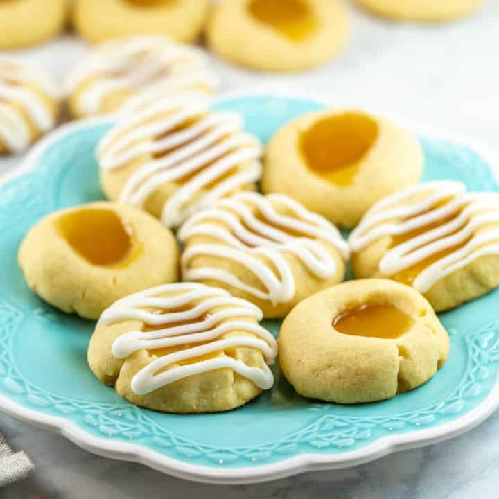 Lemon Thumbprint Cookies: Filled with lemon curd, topped with lemon glaze, and baked with lemon zest, these triple lemon thumbprint cookies are surprisingly quick and easy - but seriously delicious! #bunsenburnerbakery #thumbprintcookies #cookies #lemon #lemoncurd 