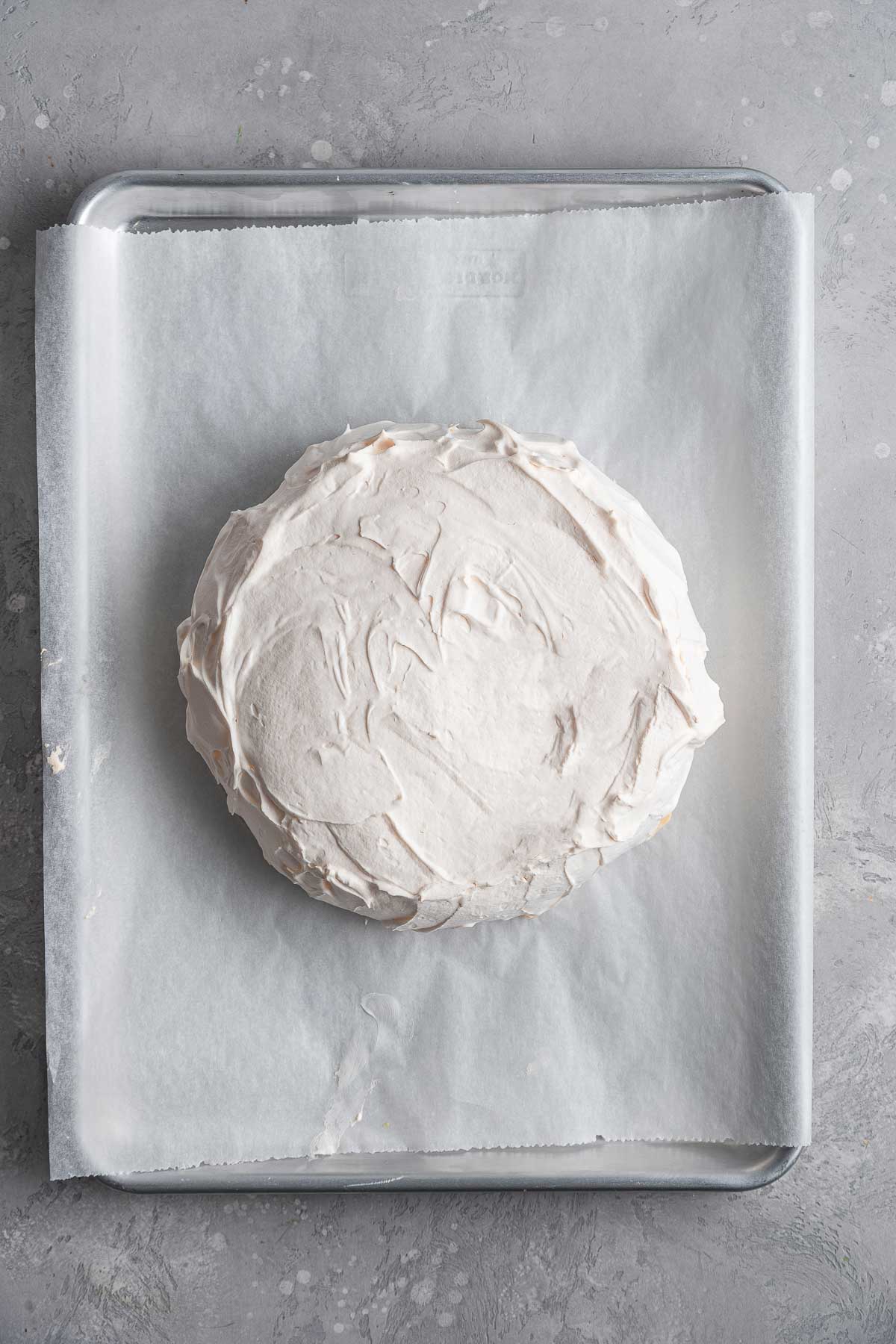 pavlova on a parchment lined sheet pan after baking