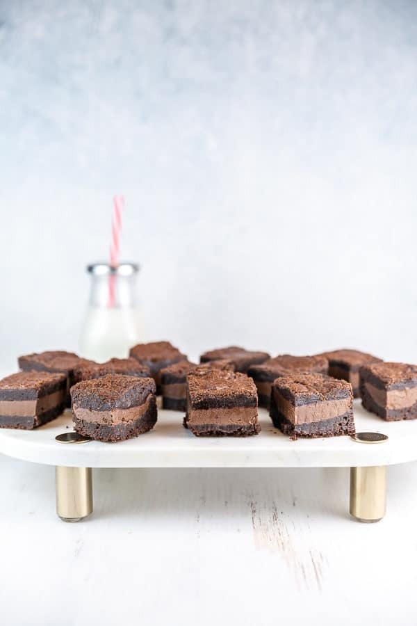 nutella stuffed brownies with a thick layer of nutella on a marble serving board