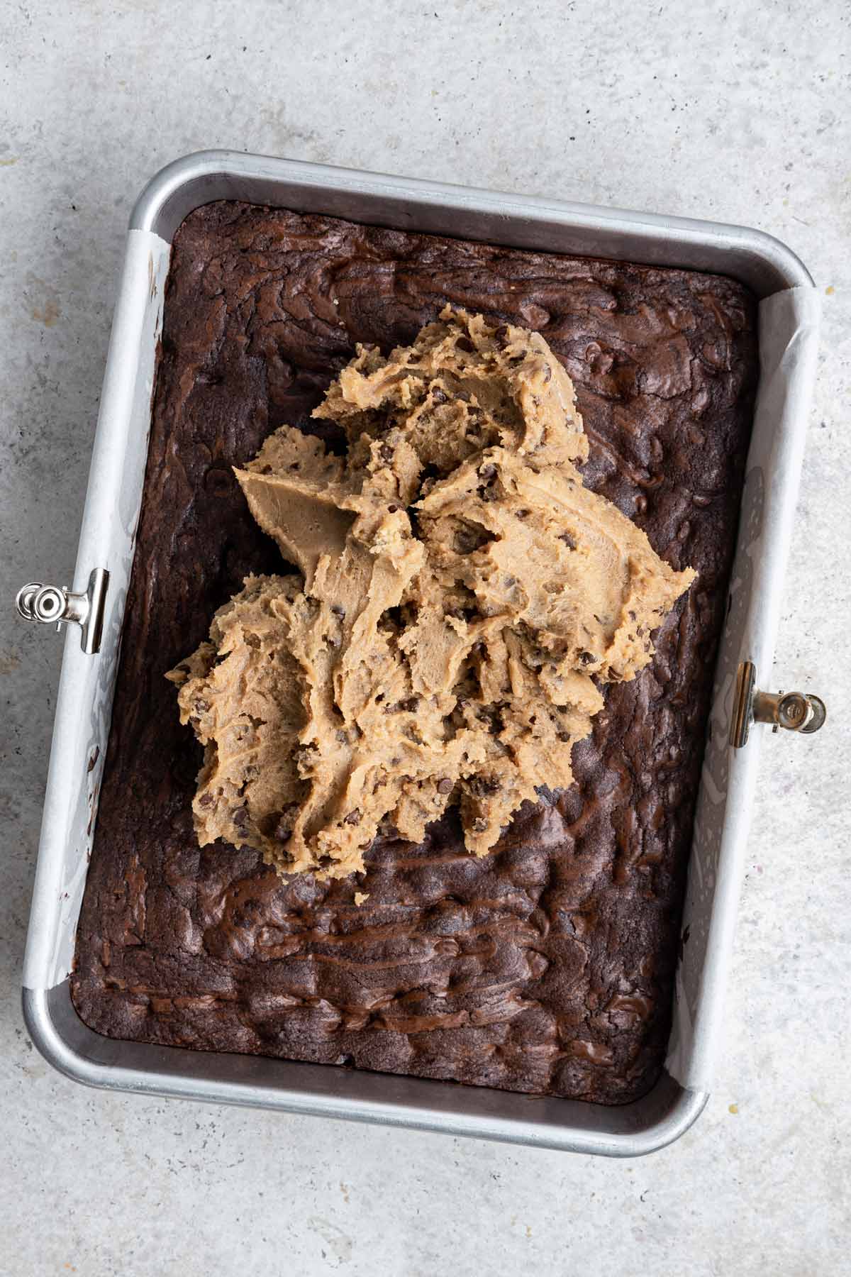 pan of brownies with cookie dough dip piled on top
