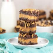 Peanut Butter Stuffed Brownies: an easy homemade recipe for fudgy brownies stuffed with a thick layer of peanut butter and topped with peanut butter chips and a peanut butter drizzle! #bunsenburnerbakery #brownies #peanutbutterbrownies #chocolatepeanutbutter