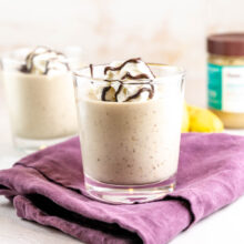 glass filled with plant-based vegan tahini shake with a dollop of whipped cream and chocolate drizzle