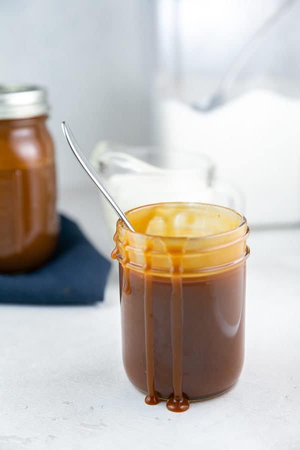 jar of caramel sauce with drips of caramel running down the side