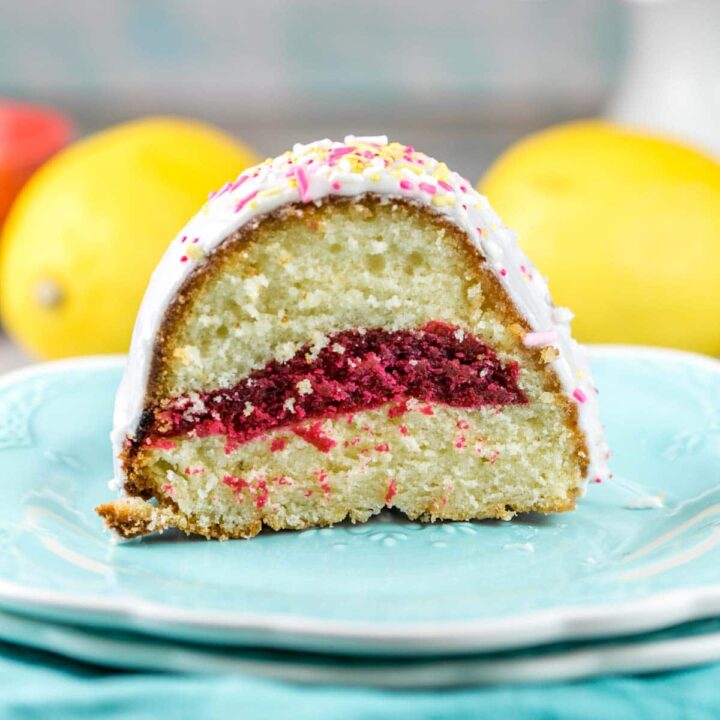 one slice of a glazed lemon bundt cake with a pink lemonade swirl in the middle