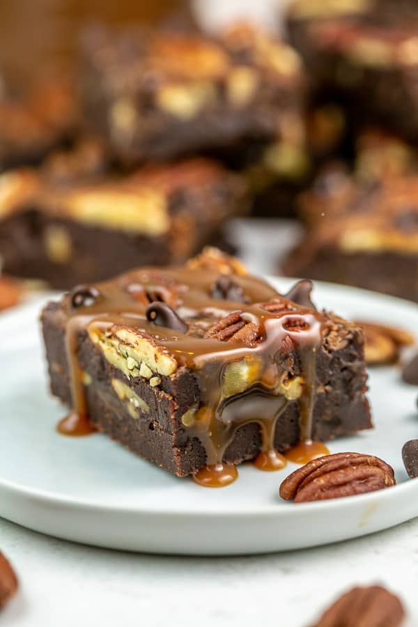 one brownie on a dessert plate dripping with caramel sauce