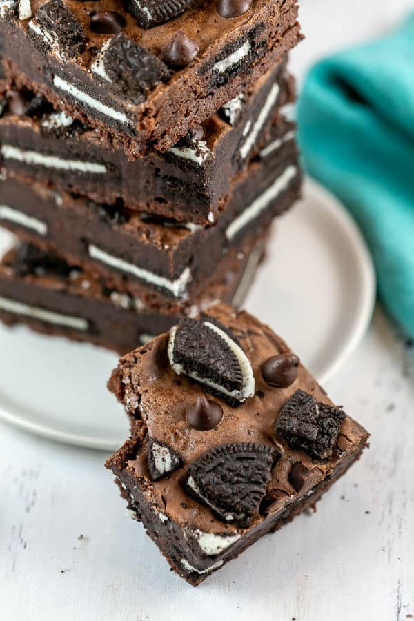 a stack of oreo stuffed brownies on a plate with a bite taken out of one