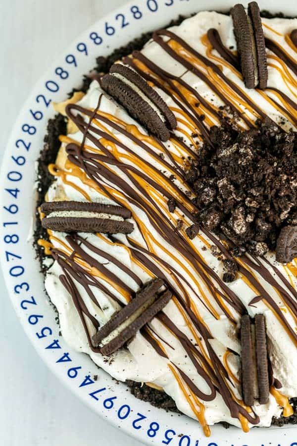 overhead view of a peanut butter pie decorated with whipped cream and oreos