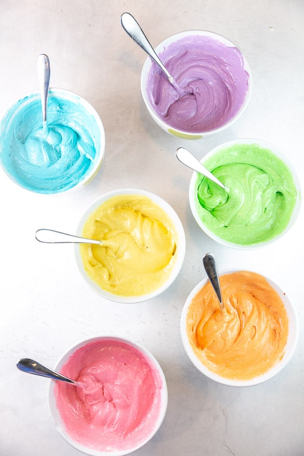 six bowls of batter dyed with food coloring