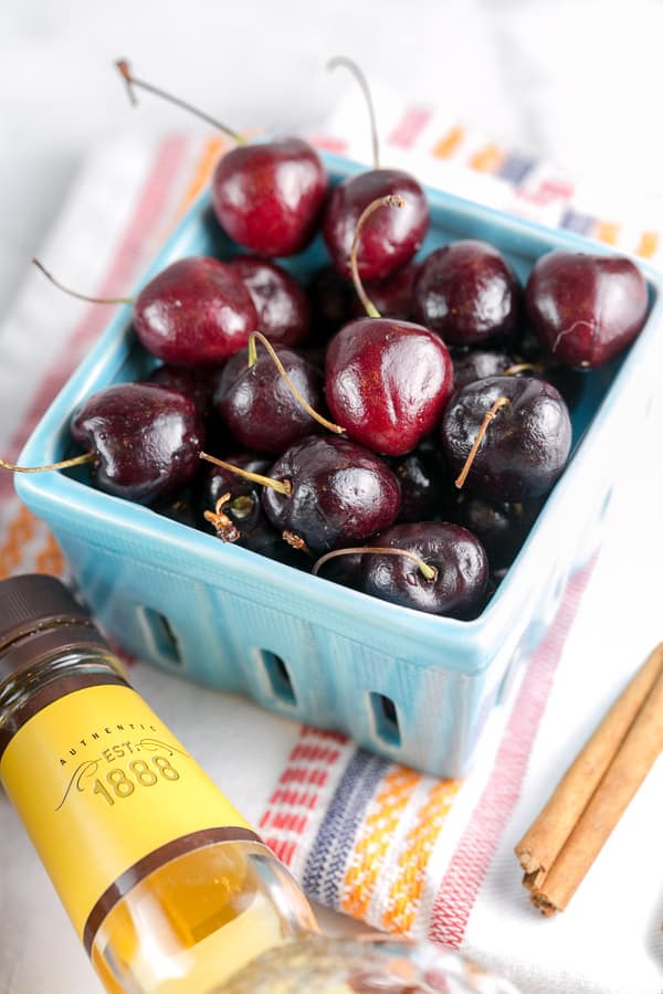 blue ceramic pint container filled with dark bing cherries